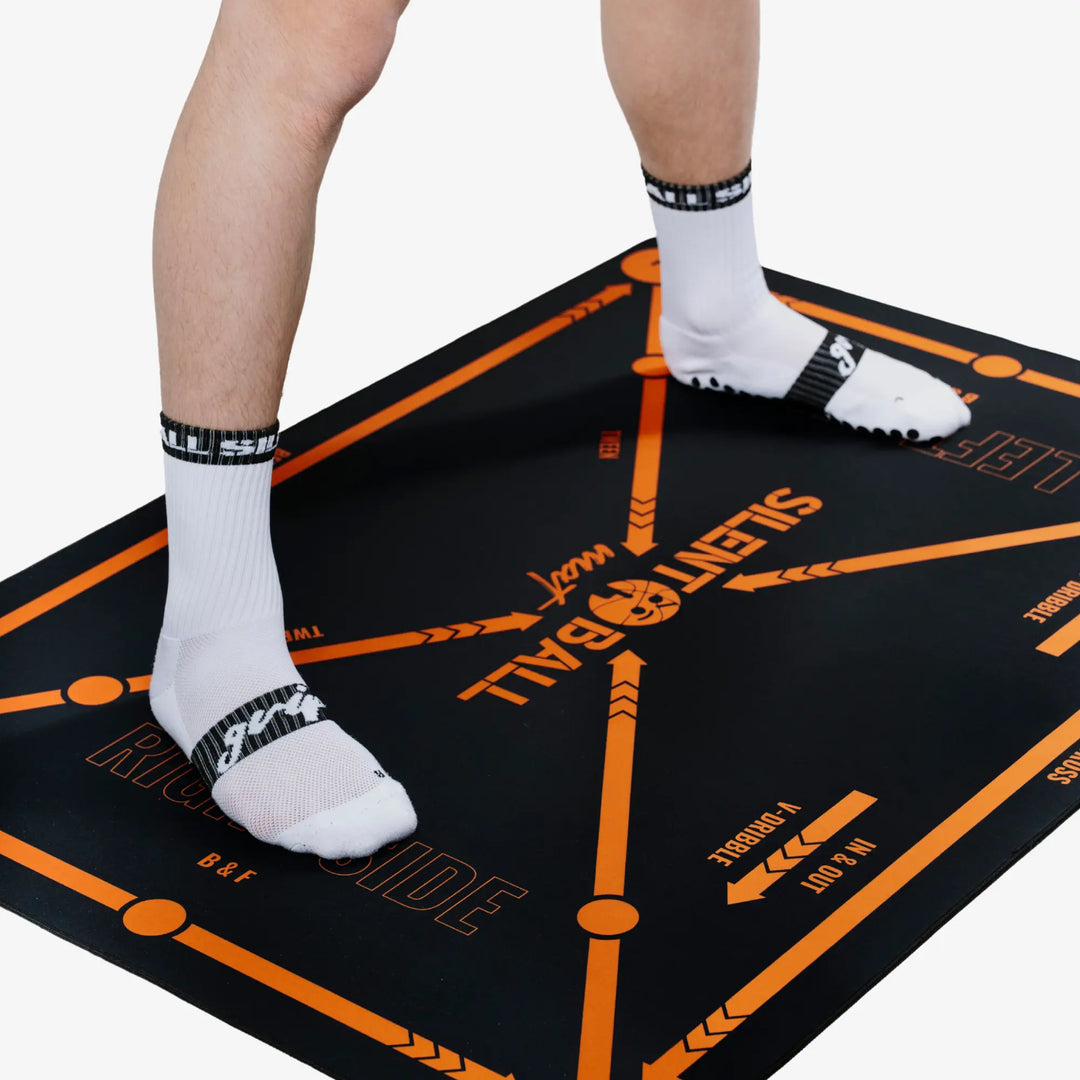 A person standing on the SilentBall training mat, demonstrating its size and providing a sense of scale for at-home basketball training
